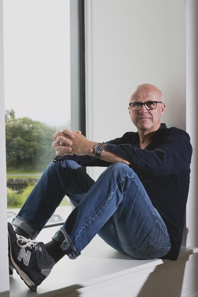 Tim Crouch sitting by a window